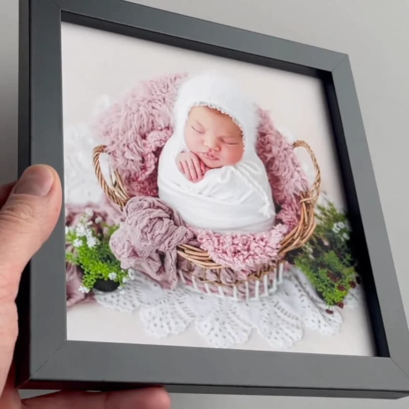 Hand hält einen Framky-MDF-Rahmen ohne Glas und zeigt einen Pigmentdruck auf mattem Fotopapier